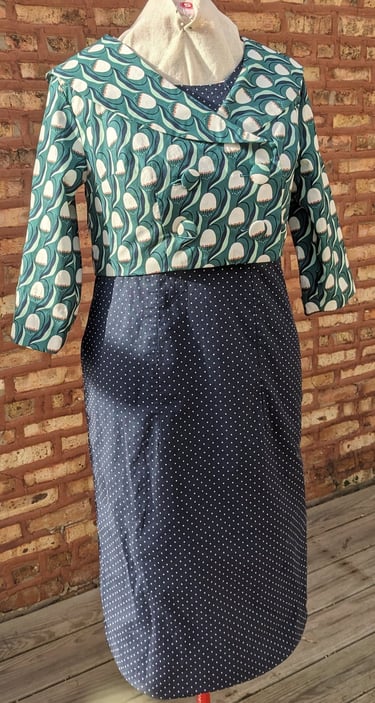 The front of a navy polka dot reversible sheath dress and green 50's inspired jacket