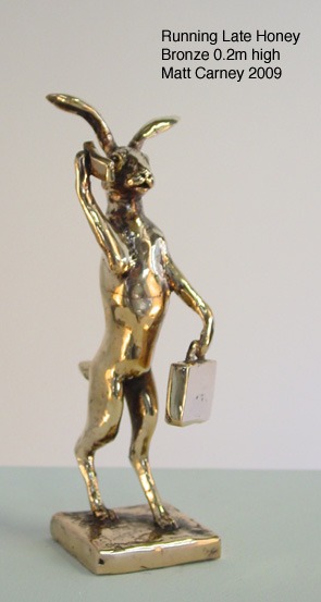 a statue of a rabbit with a briefcase talking on the phone