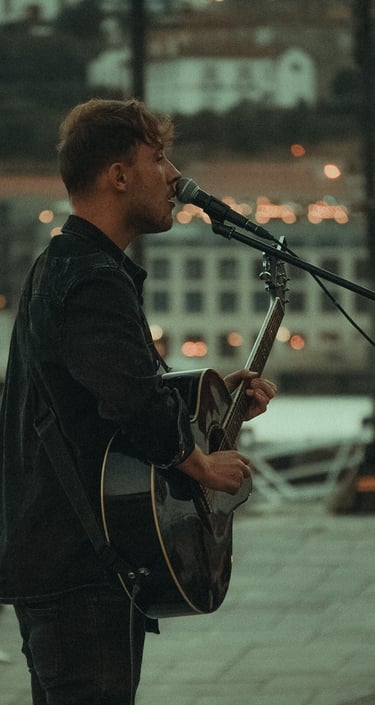 Fotografía de un hombre cantando en el paseo del río de Oporto