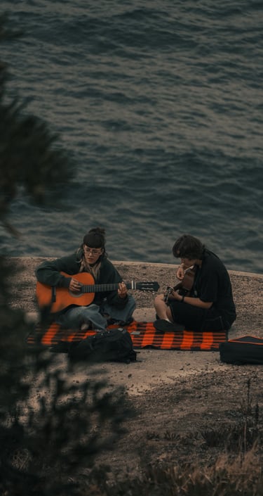 Forografía de dos personas tocando la guitarra en el Monte de San Pedro, A Coruña