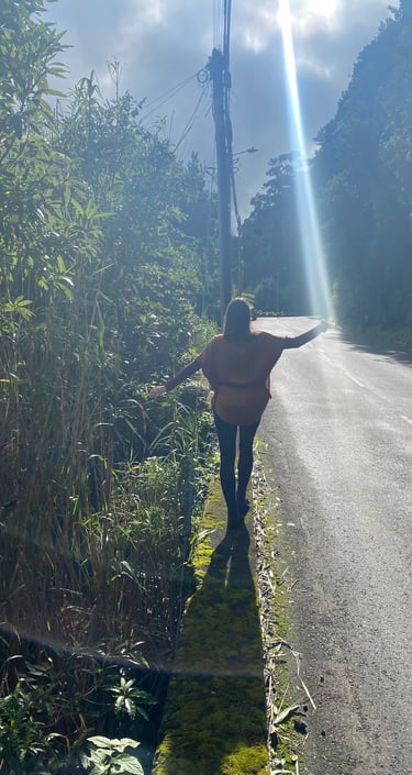 Julia Braun balanciert auf einer Mauer. Es trifft ein Sonnenstrahl genau ihre ausgestreckte Hand