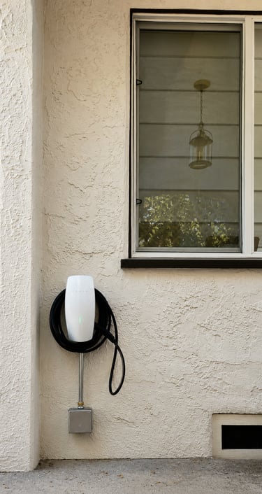 Tesla Wall Connector Level 2 residential EV charger installed on an exterior wall