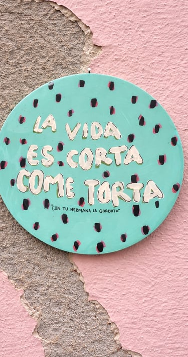 Letrero redondo de color turquesa pintado a mano sobre una pared rosa 