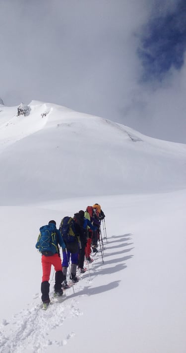 Grup fent una ruta en raquetes de neu a un cim del pirineu
