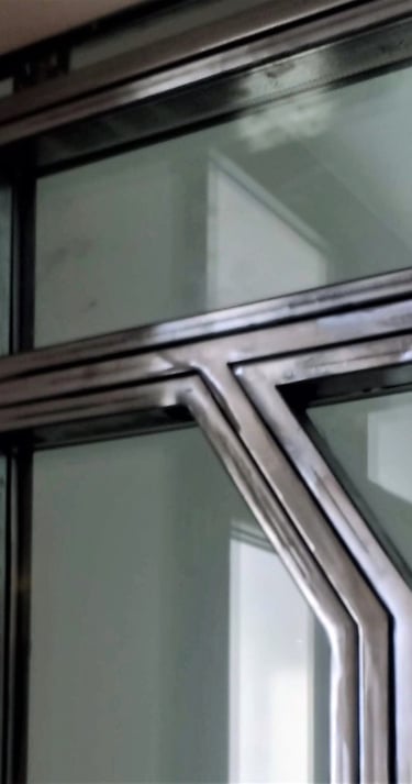 A glass door with custom-made raw steel elements