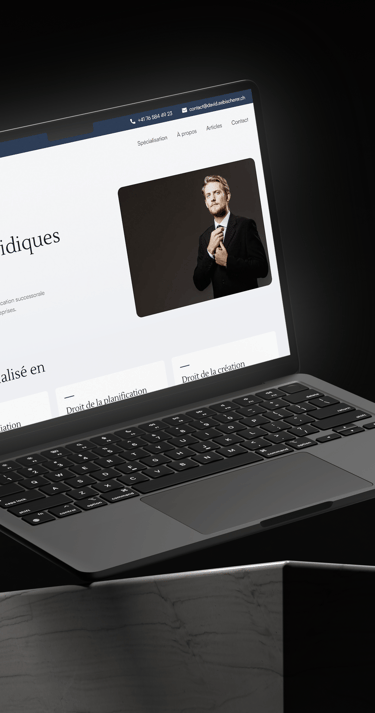 A laptop computer on a desk displaying the David Aebischer website.