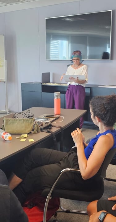 Gabriela Bechara Zillig conduz dinâmica de Design Sprint em uma sala de reunião para colegas