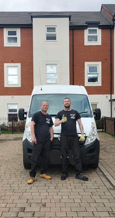 two men standing next to a van