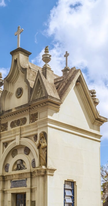 A imagem mostra uma igreja com uma torre de relógio no meio do cemitério araçá