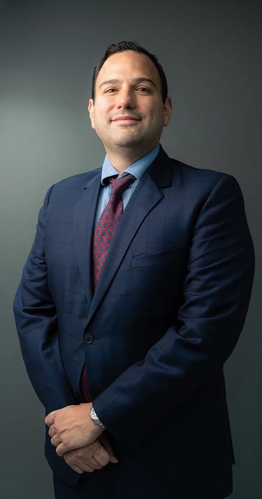 Fotografía profesional corporativo de hombre con terno azul, corbata roja en fondo gris de Quito, Ecuador