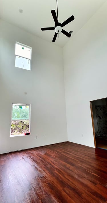 Primary bedroom with 20-foot ceilings and oversized windows in Texas custom home