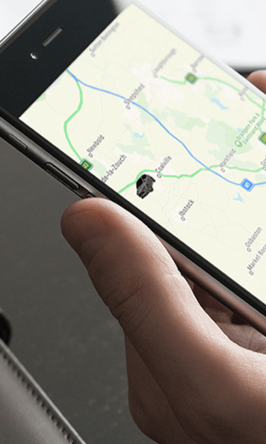 SmarTrack vehicle tracking app on smartphone showing live location map.