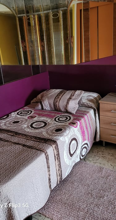 Cama y espejo de la habitación