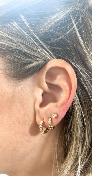 a woman with a gold earring and earrings