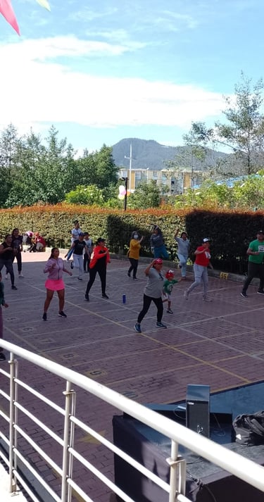 Grupo de personas disfrutando de una clase de Zumba en un ambiente animado y divertido.