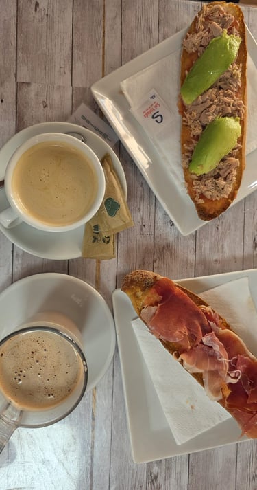 a table with a cup of coffee and a sandwich