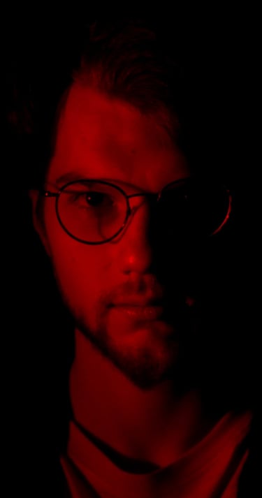 Thomas Rateau, le bassiste du groupe Rush On Mars éclairé de face par une Lumière rouge
