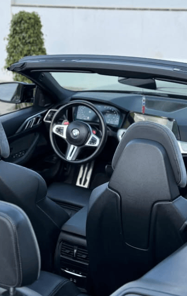 Interior view of a modern BMW convertible featuring black leather sports seats and a luxury dashboard.