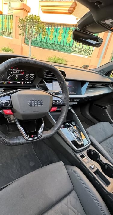 Luxury interior of an Audi RS model showing the leather steering wheel, digital dashboard, and sport seats.