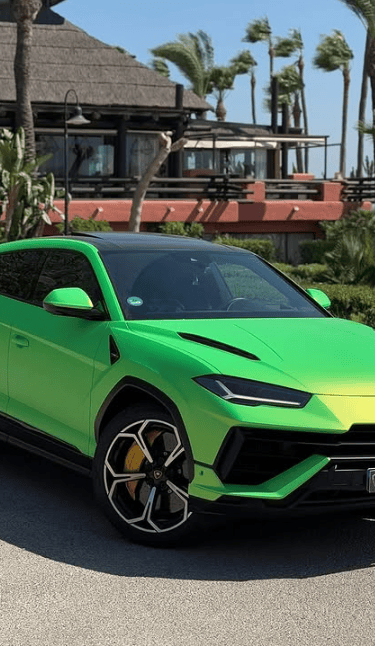 Luxury neon green Lamborghini Urus SUV parked at a tropical resort for rent.