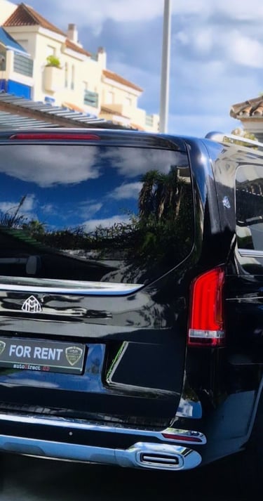Black Mercedes-Benz Maybach luxury van available for rent parked in front of a residential building.