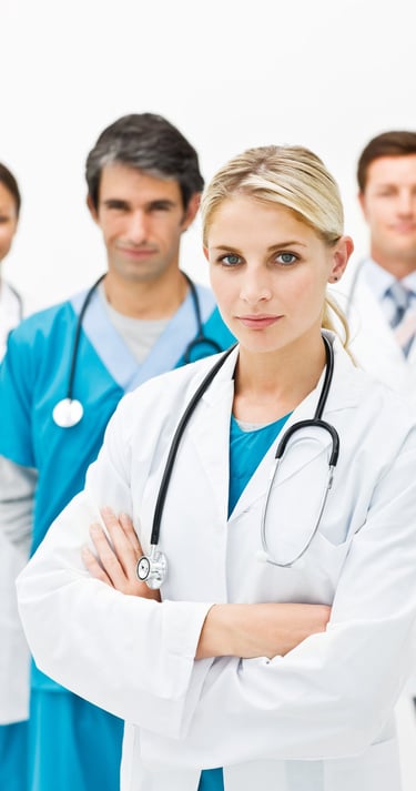 A diverse team of medical doctors and healthcare professionals in white coats and scrubs with stethoscopes.