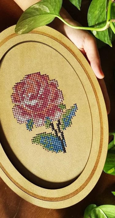 Marco ovalado con bordado de una rosa en punto de cruz 