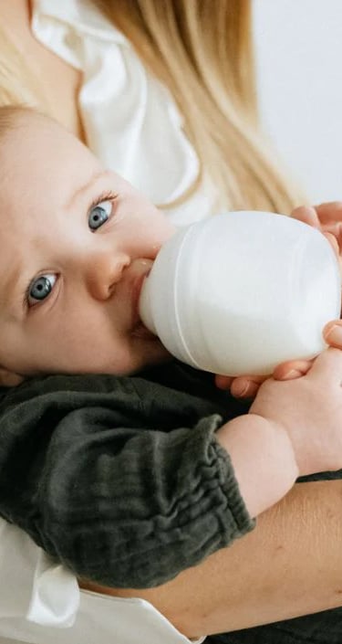 Anne kucağında biberonla beslenen bebek – beslenme desteği