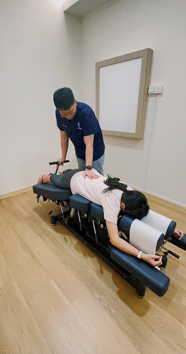 Chiropractor performing spinal adjustment on female patient at Sinisana Chiropractic clinic.