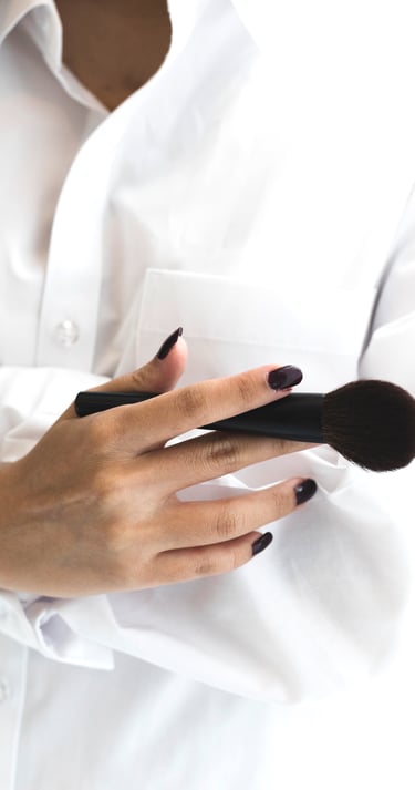 Vrouw met wit hemd en schmink borstel vast 