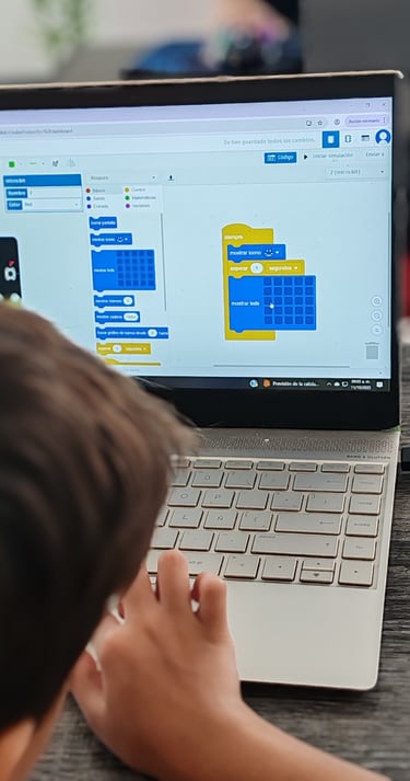 Niño aprendiendo programación por bloques en una computadora.