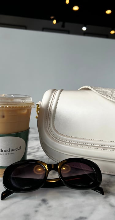 a white purse with sunglasses and a coffee cup