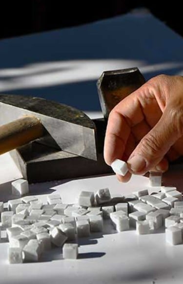 a person is using a hammer hammer to make a block of white cubes