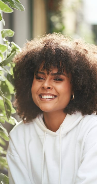 A Black girl with long curly hair and a communicative smile posing during a photo session