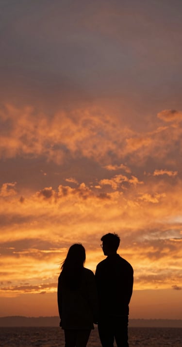 A silhouette of a couple against a terracotta orange sunset sky in a North American / US coastal environment.