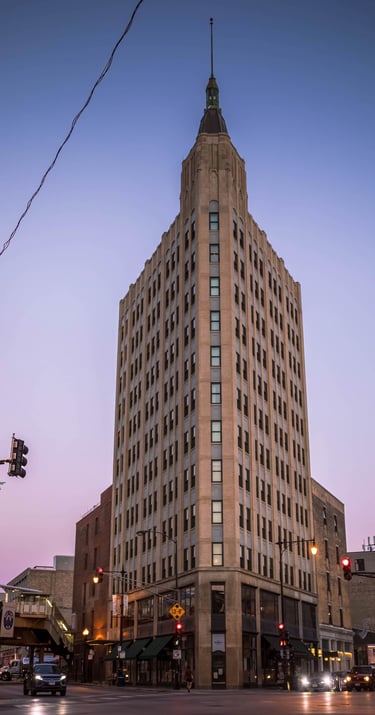 a tall building with a clock tower in the middle of the street
