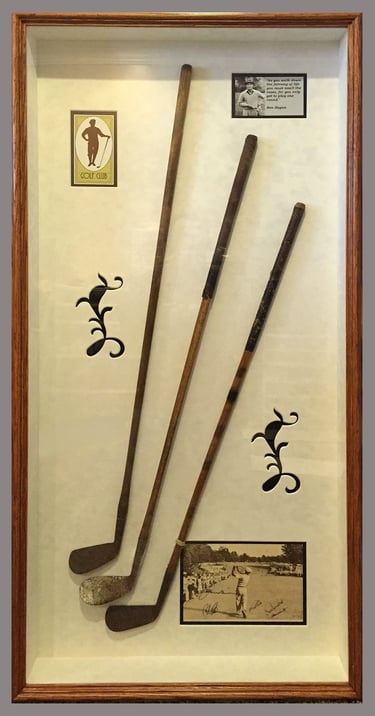 Vintage hickory shaft golf clubs in a shadow box frame with historic photos and golf club logo.