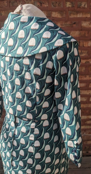 The back of a green art nouveau reversible sheath dress and 50's inspired cropped jacket