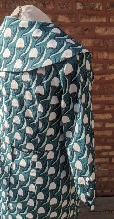 The back of a green art nouveau reversible sheath dress and 50's inspired cropped jacket