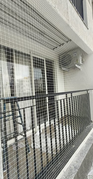 a building with a Balcony nets installed in area with a fenced in area