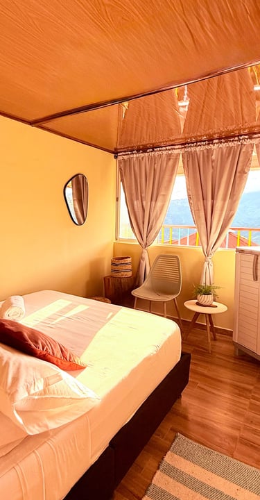 Habitación sencilla con cama doble, ventana con vista a la montaña