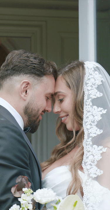 A bride and groom gaze lovingly at each other, surrounded by a soft, romantic atmosphere.