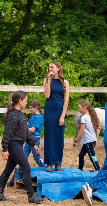 a girl in a blue dress standing on a blue blanket