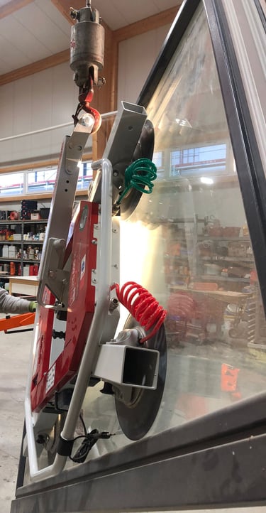 Schreinermeister Ferdinand Volk mit Glasscheibe am roten Vakuum-Saugheber in der Halle.