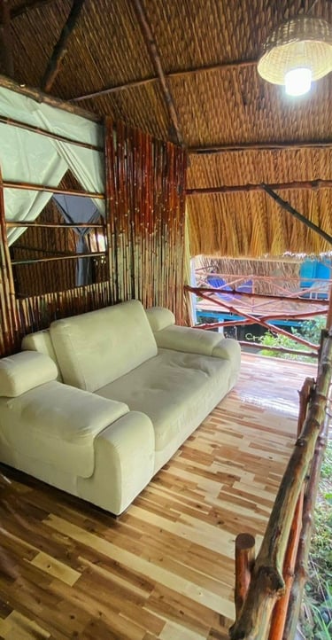 Cozy room with a comfortable sofa on the porch, perfect for relaxing in a rustic bamboo hut.
