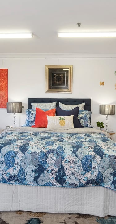 Cozy bedroom at Marche Home Stay with a queen bed, colourful artwork, soft lighting, and a welcoming, homely atmosphere.