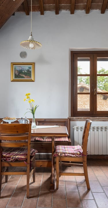 Rustic Italian kitchen with wood cabinets, terracotta tile floors, and a wooden breakfast nook.