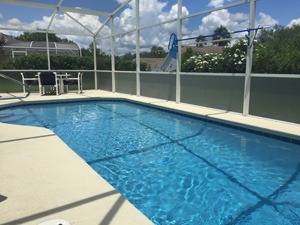 a swimming pool with chairs and table in Florida