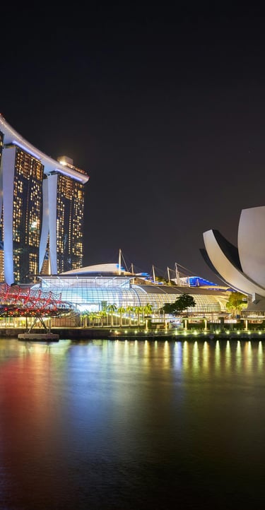 Singapore Marina Bay Sands and Helix Bridge illuminated at night with city skyline reflections