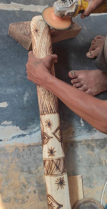Artisan polishing a bamboo handicraft engraved with traditional tribal designs using an electric too